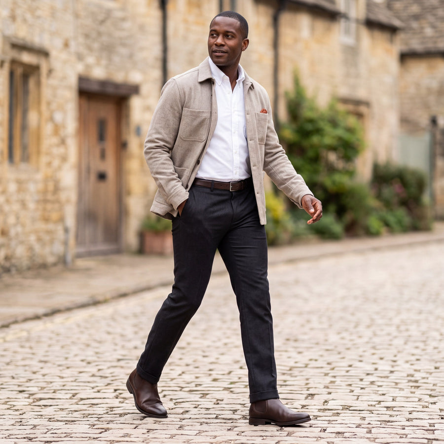 Man styling tailored trousers on a Cotswolds village street