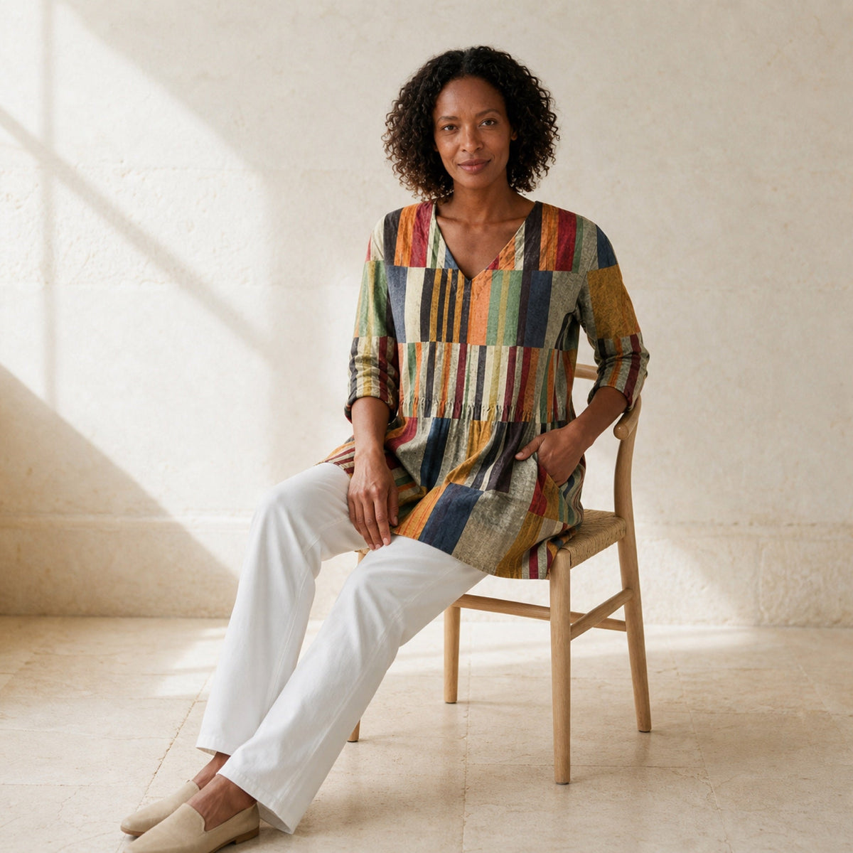 Chloe multicolour patchwork stripe tunic styled seated with white trousers