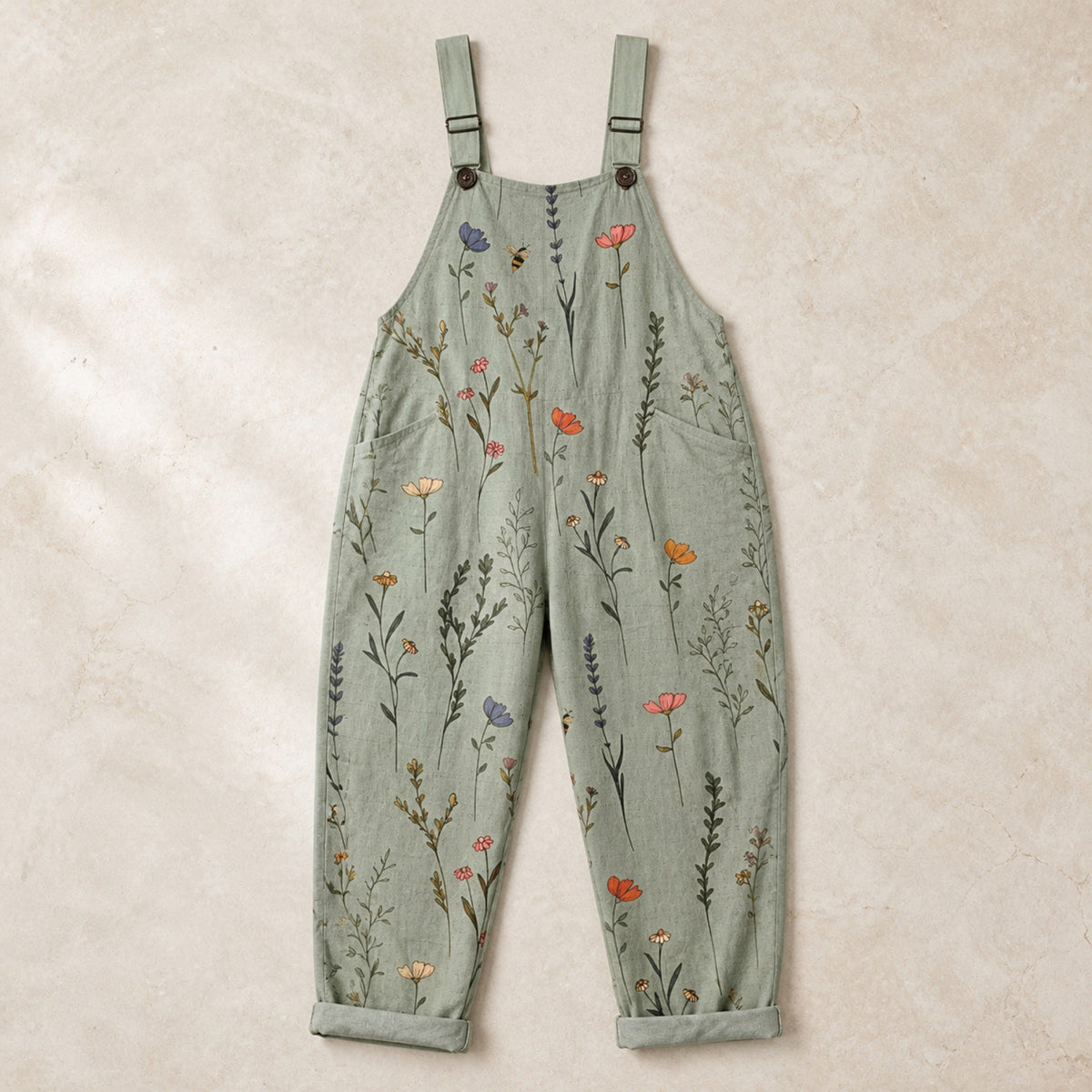 Sage green floral printed dungarees arranged in a clean flat lay
