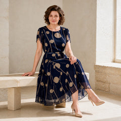 IVY navy and beige chiffon midi dress styled seated in a cream studio
