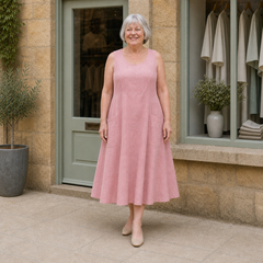 Margaret wearing the pink Luna Comfortable A-Line Midi Dress, contextual full-body view outside the Cotswold stone boutique.