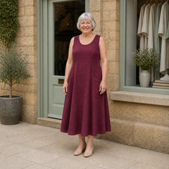 Margaret wearing the crimson Luna Comfortable A-Line Midi Dress, front full-body view outside the Cotswold stone boutique.