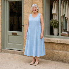 Margaret wearing the light blue Luna Comfortable A-Line Midi Dress, front full-body view outside the Cotswold stone boutique.