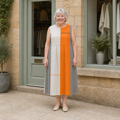 Margaret wearing the multicolour May Colorblock Midi Dress, front full-body view outside the Cotswold stone boutique.