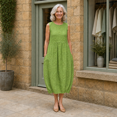 Rose wearing the green Rose Embroidered Midi Dress, front full-body view outside the Cotswold stone boutique.