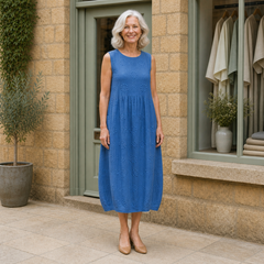 Rose wearing the blue Rose Embroidered Midi Dress, front full-body view outside the Cotswold stone boutique.