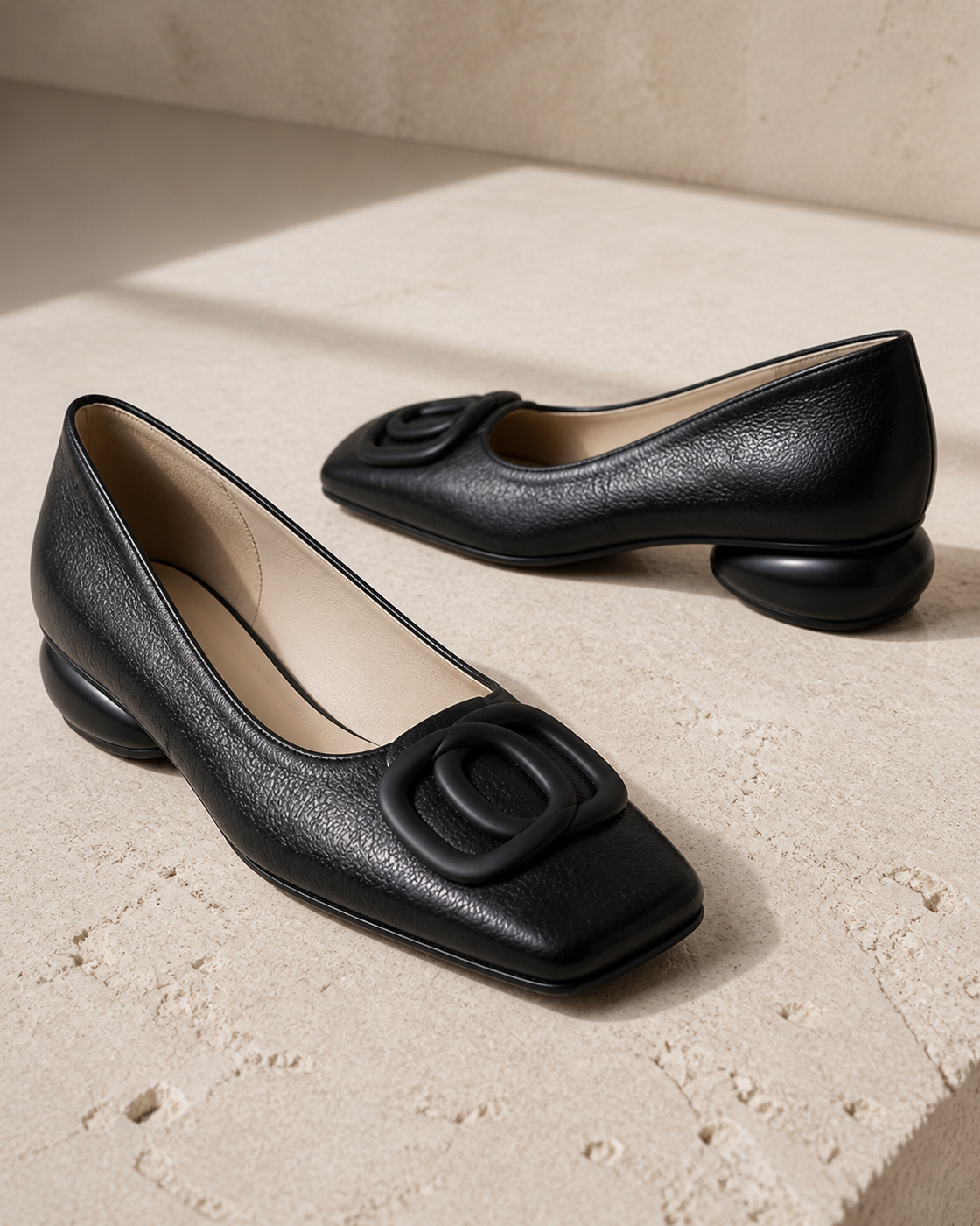 Opium black square-toe flats on Cotswold limestone