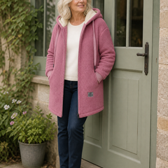 The Phoebe pink longline hooded fleece jacket styled by a sage cottage door